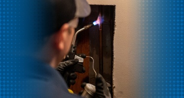 A close-up of a technician repairing a pipe, showcasing professional pipe repair services