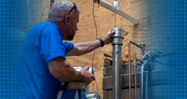 A commercial plumber inspecting a pipe in a business setting, representing commercial plumbing services.