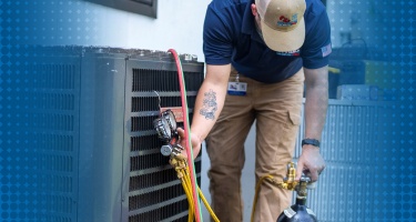 HVAC technician performing AC maintenance check