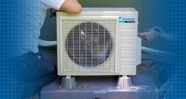 Daikin ductless mini-split air conditioning system mounted on a wall, showcasing its compact design.