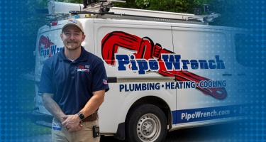 A technician standing near the Pipe Wrench truck.