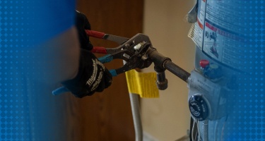 A plumber repairing a water heater, ensuring efficient water heating performance