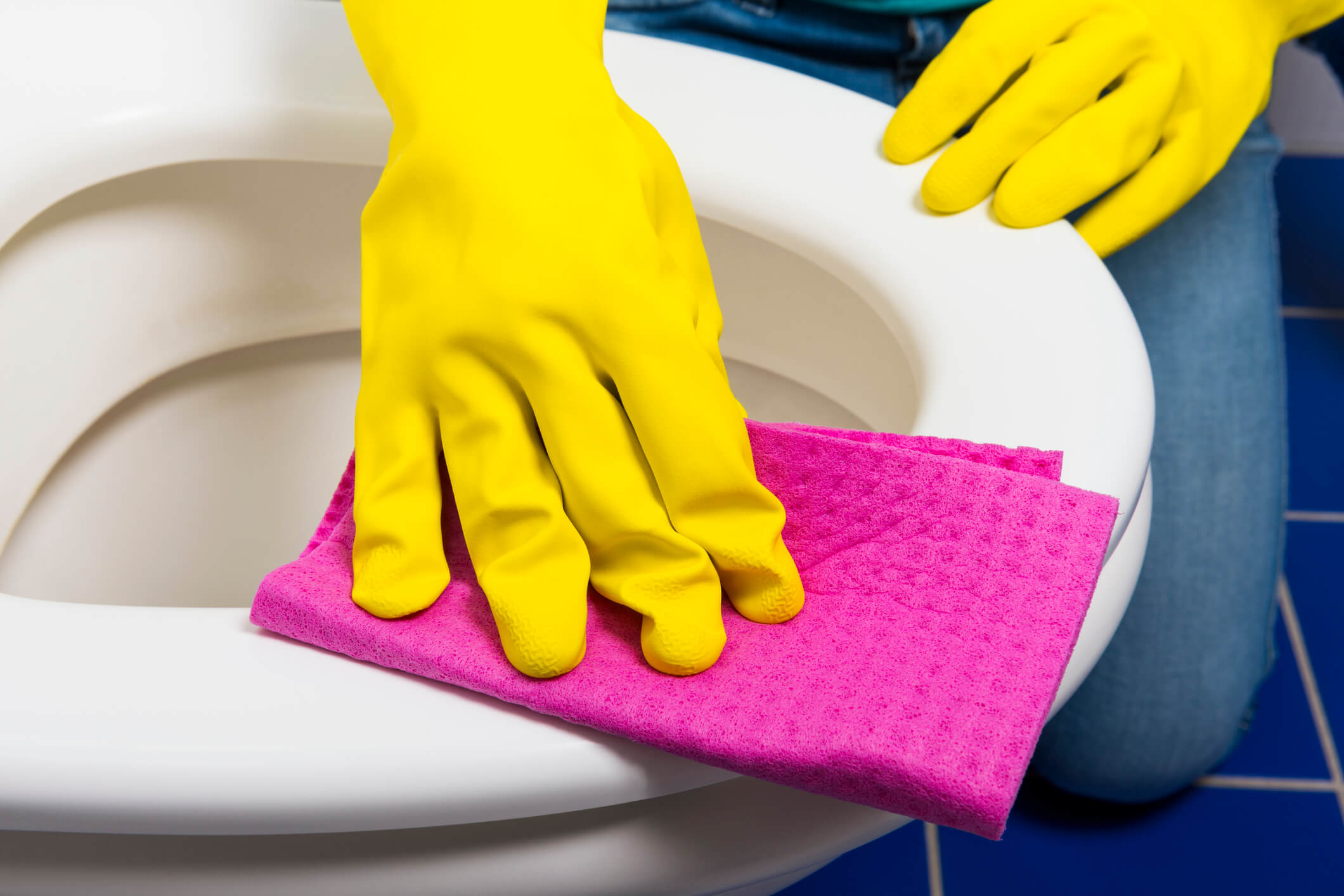 person scrubbing toilet seat
