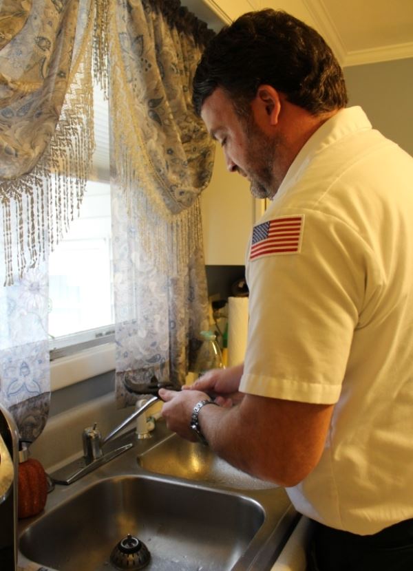 technician repairing a leaky faucet