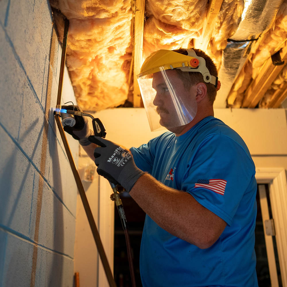 Plumber repairing a home's water pipe.