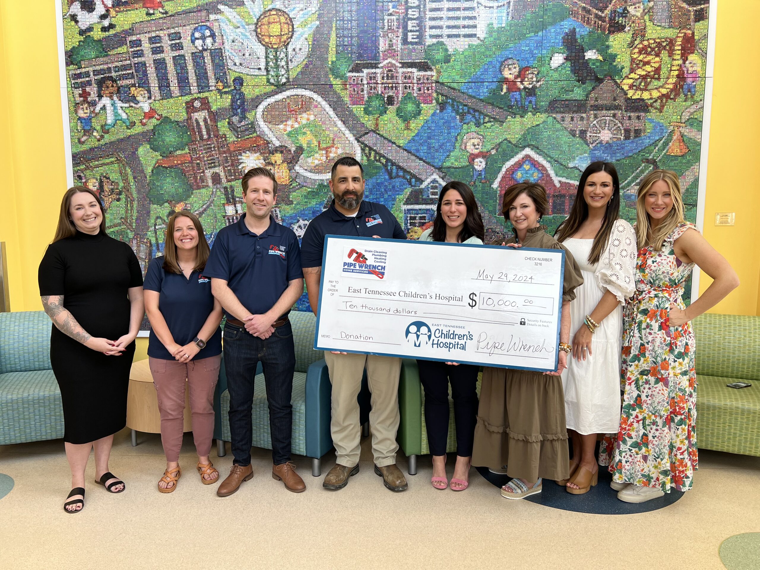 Group holding a large donation check