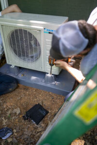 Technician maintaining and outdoor mini-split unit.