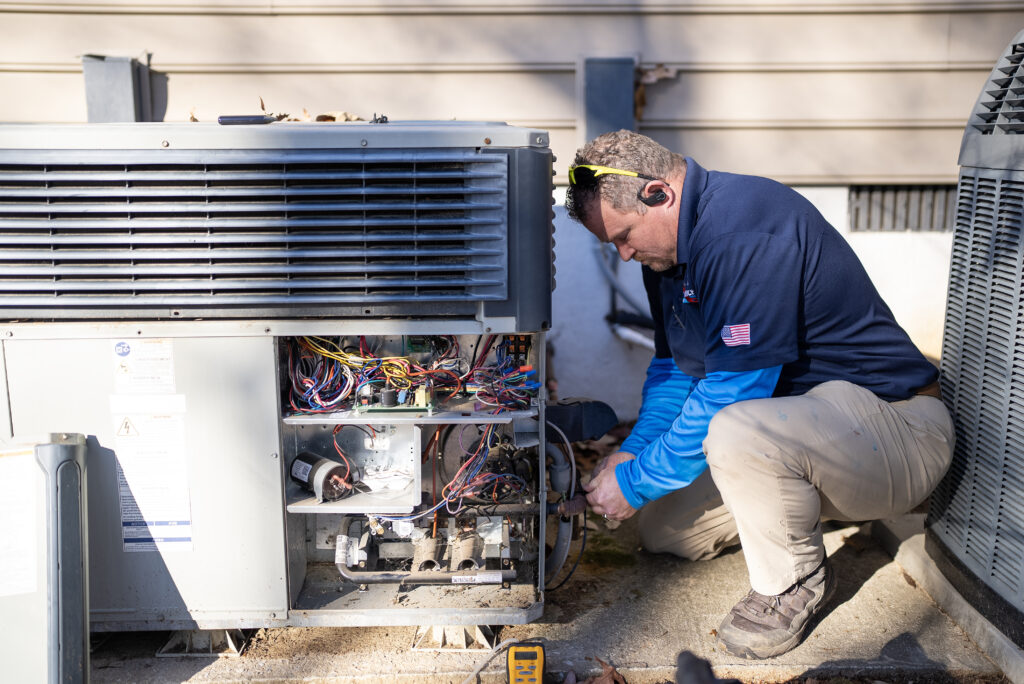 Technician showcasing a packaged HVAC unit outdoors in a professional setting.